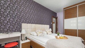 Ein Hotelzimmer mit Bett, Nachttisch, Lampe und Schreibtisch mit Stuhl.