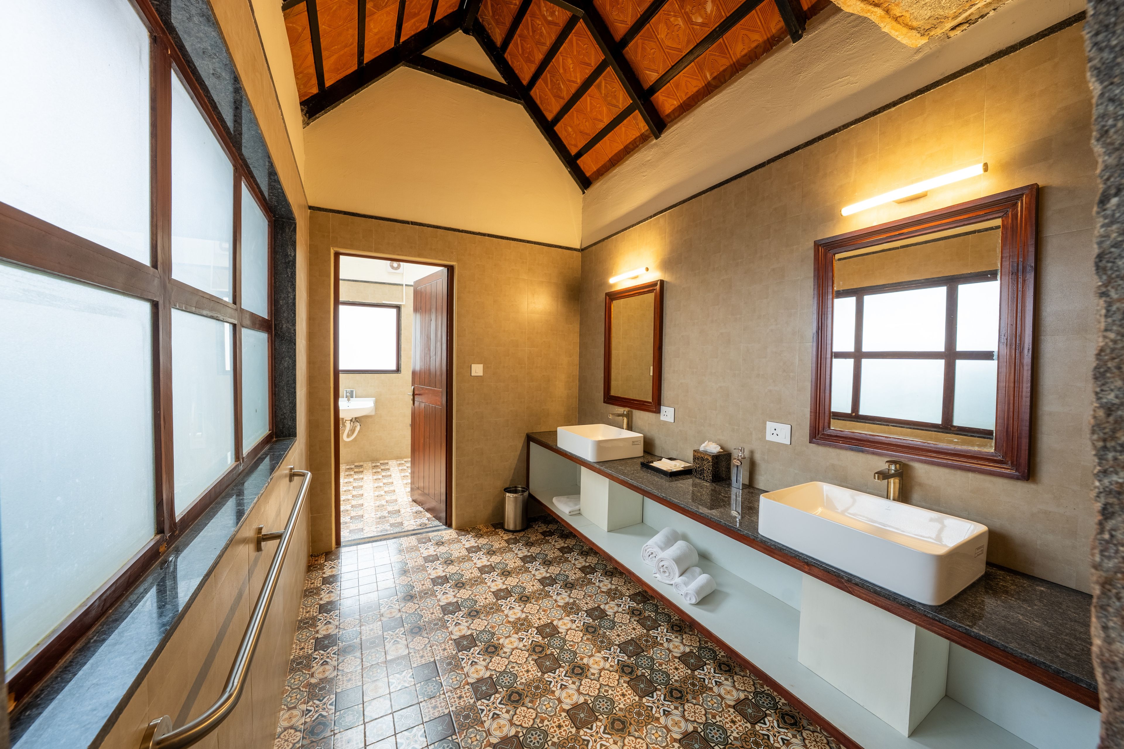 Ein Badezimmer mit zwei Waschbecken, einem großen Spiegel und einem fußbodenmuster.