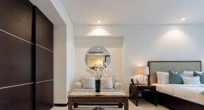 A modern hotel room with a bed, bedside table, lamp, and a mirror. - The Splendid • JW Marriott (Dubai)