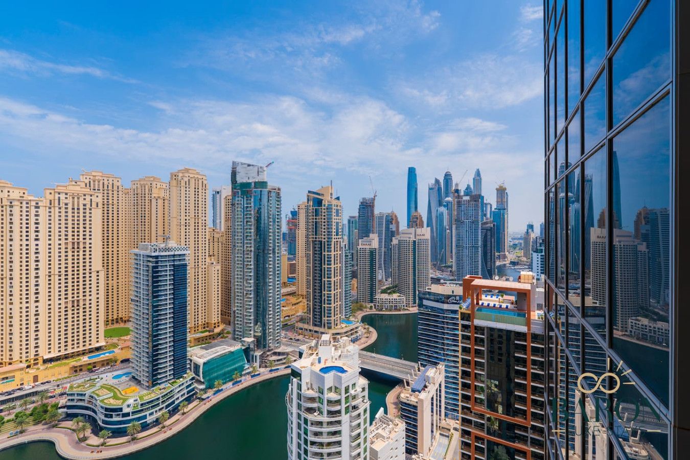 A high-rise building with a view of a city skyline, including several skyscrapers and a body of water.