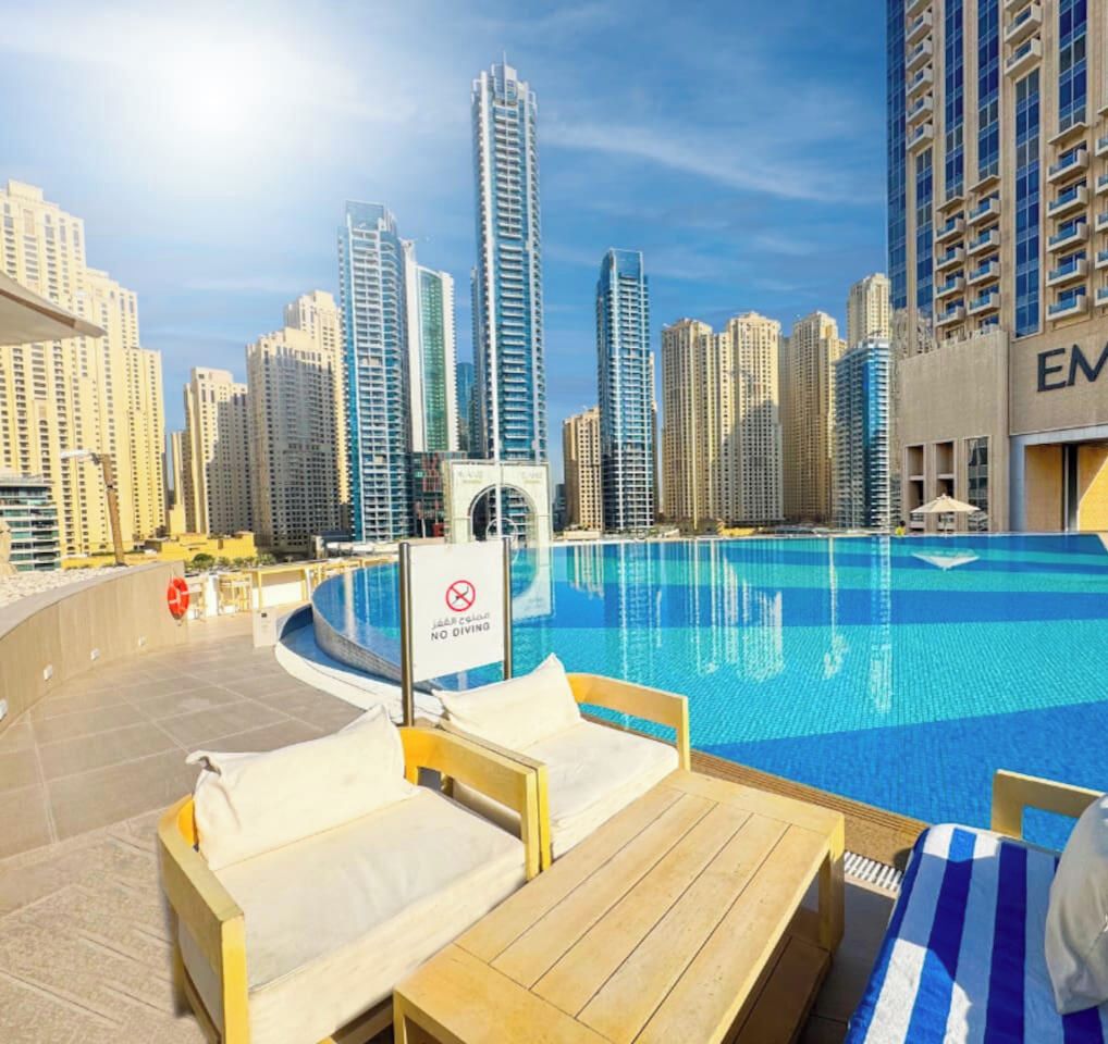A swimming pool with lounge chairs and a sign indicating no diving.