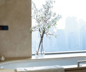 Vista despejada de una ventana con un florero de flores blancas sobre el alféizar.