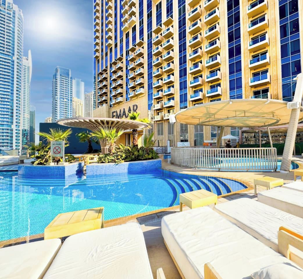 Un hotel con piscina, posti a sedere all'aperto e una zona coperta.