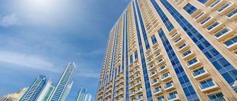 Un immeuble de grande hauteur doté de nombreux balcons, avec un ciel dégagé.