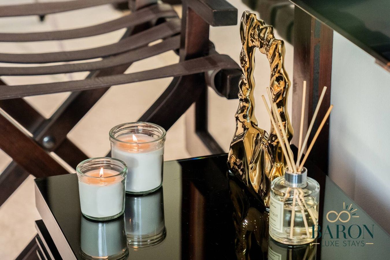 A table with two candles and a perfume bottle.