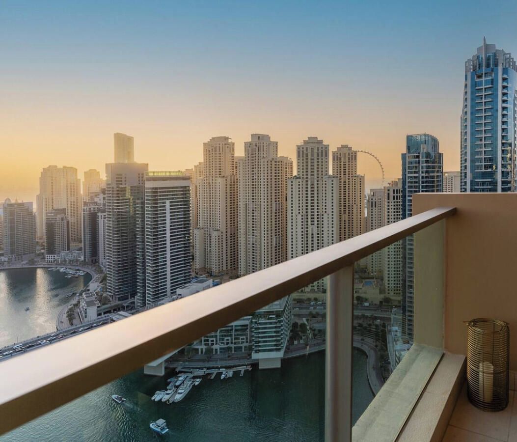 Un grattacielo con vista sullo skyline cittadino e su un corpo d'acqua sottostante.