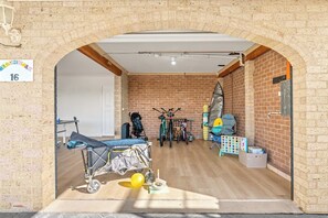 A room with a brick wall, a wooden floor, and a door labeled '16'. - Callala Beach Walk - Beachfront with Sauna (Callala Beach)