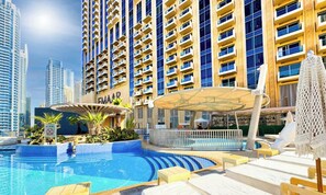 Un hotel con piscina, mobiliario exterior y un espacio cubierto.