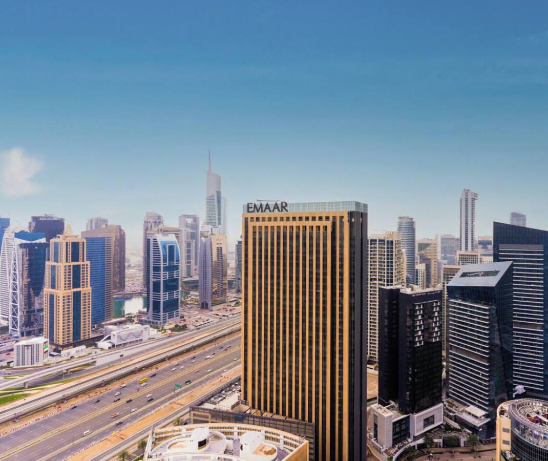 En stadsbild med moderna höghus, inklusive en framträdande byggnad med skylten ”EMAAR”.