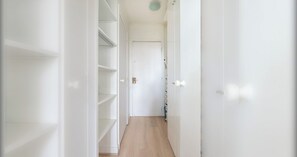 A narrow hallway with white walls and wooden flooring leading to a door at the end. - Bright Studio-15 Minutes from the Arc de Triomphe (Paris)