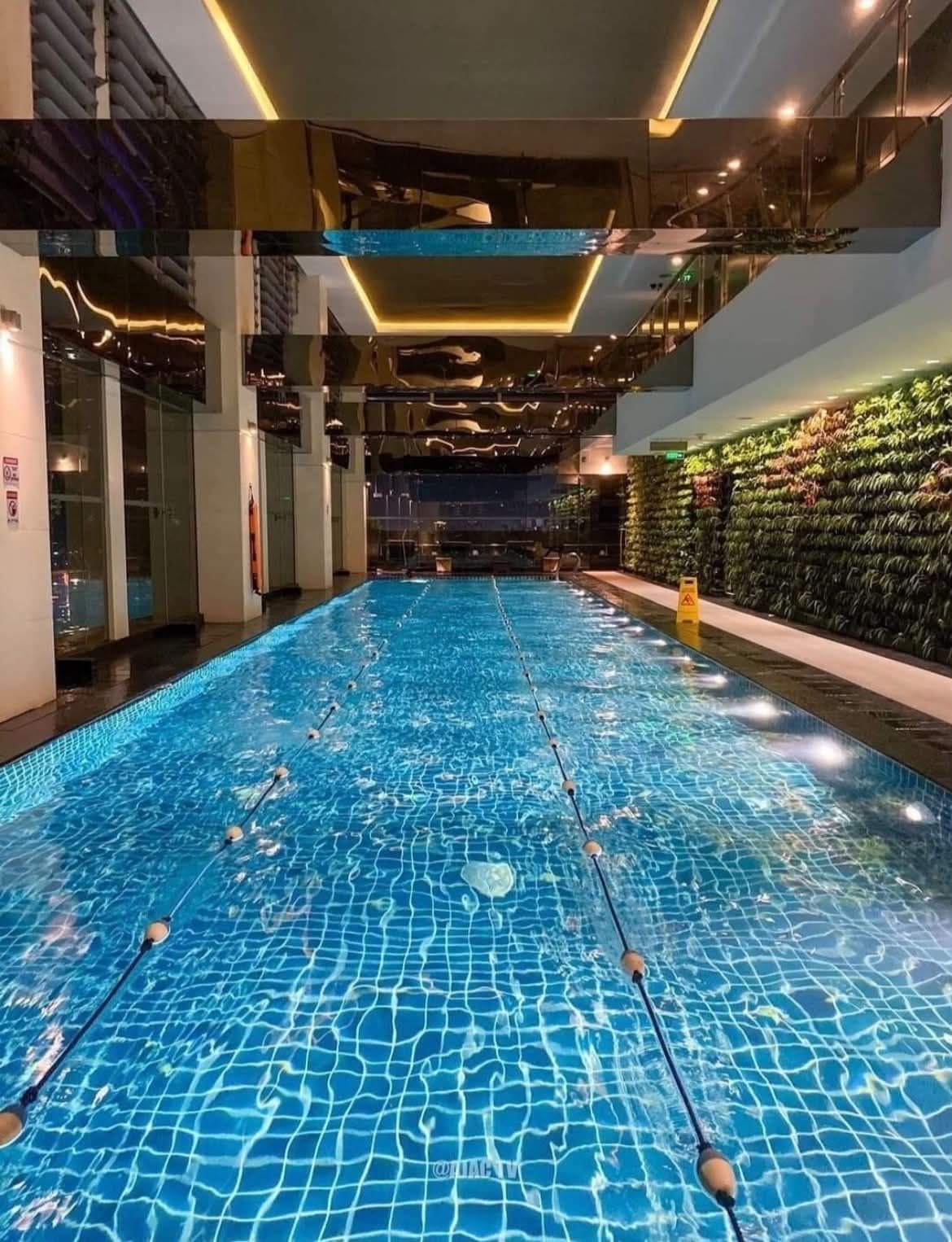An indoor swimming pool with clear water, lane dividers, and a modern interior design.