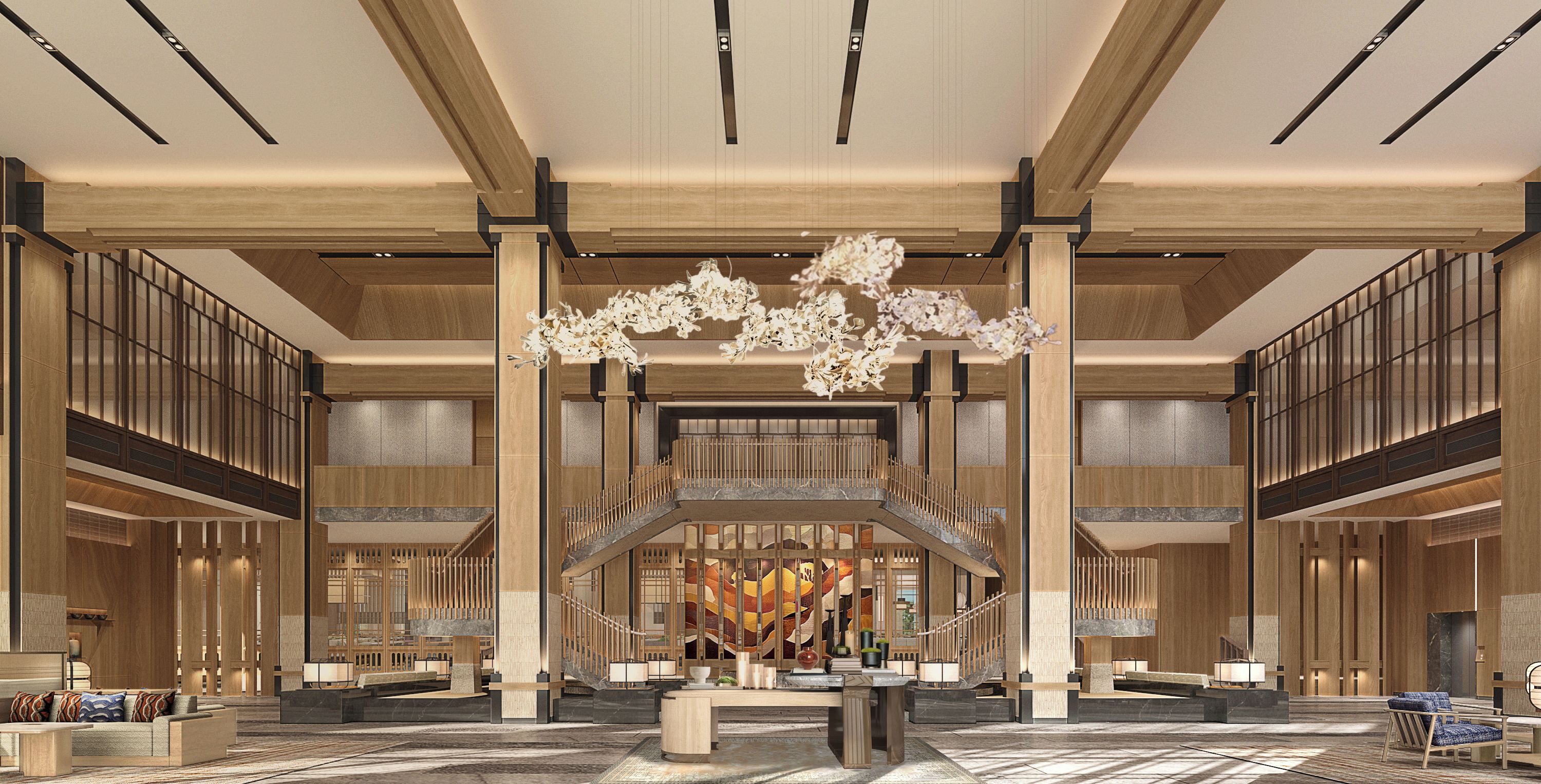 A spacious lobby with a central staircase, wooden paneling, and a chandelier.