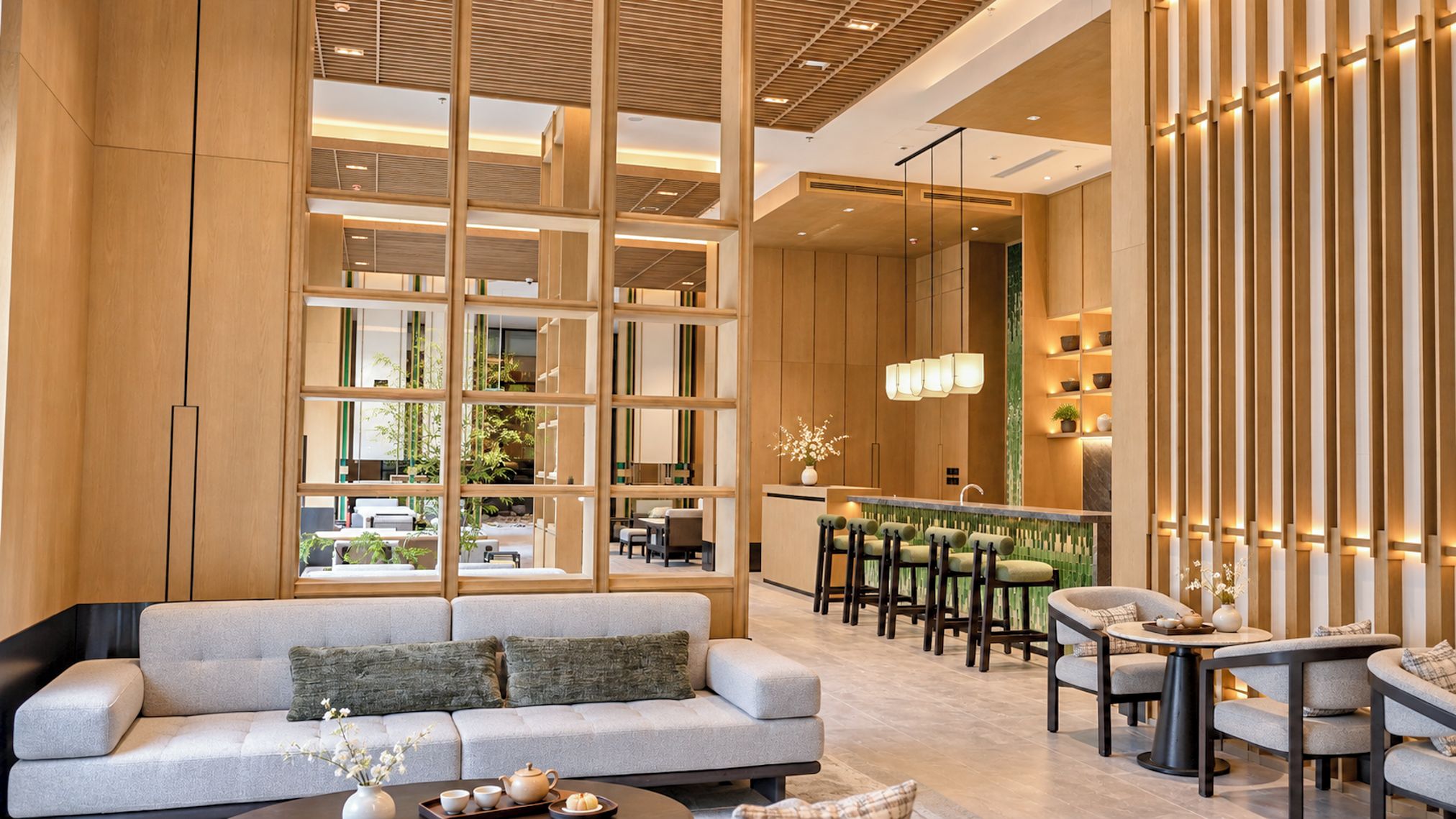 A modern hotel lobby with a sofa, bar area, and seating.