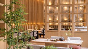 Un intérieur de style traditionnel, avec un séparateur en bois, un coin salon et une table préparée pour le thé.