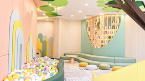 A children's play area with a ball pit, cushioned seating, and a wall with shelves. - Vinpearl Onsen Resort Tuyen Quang (My Lam)