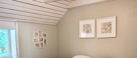 A bedroom with a bed, a window, and a ceiling light.