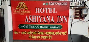 Une enseigne pour l’hôtel Ashiyana Inn, indiquant qu’il propose des chambres avec et sans climatisation.