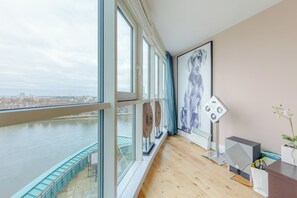A modern room with large windows overlooking a river, a cityscape, and a view of the sky. - Sleek 3BD flat with Stunning City Views, Vauxhall (London)