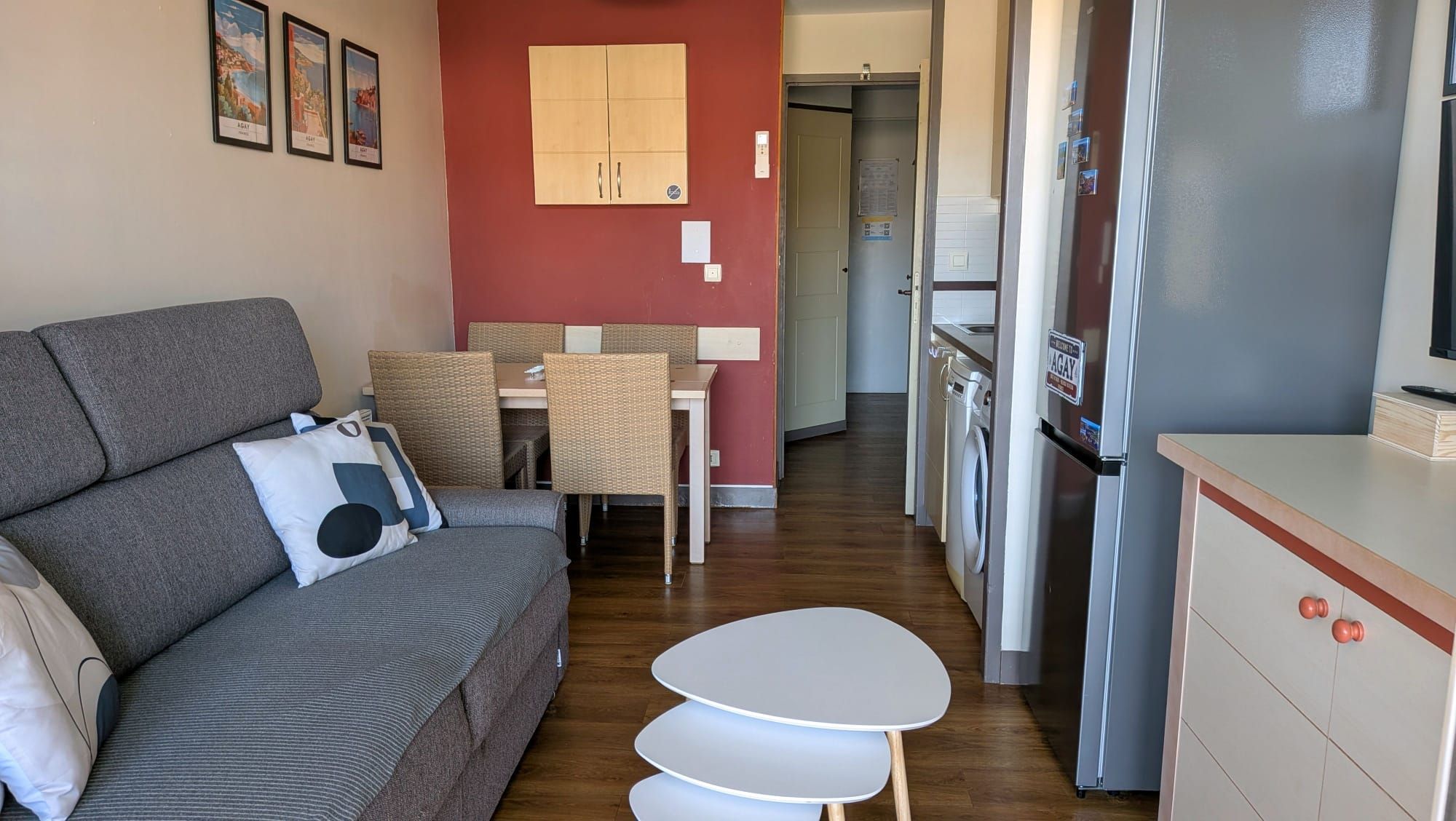 A compact living space with a sofa, a dining table, and a kitchenette area.
