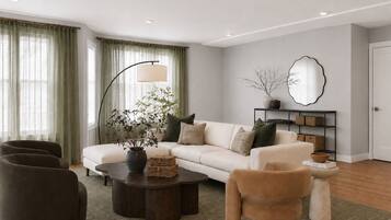 A modern living room with a sofa, armchairs, a coffee table, and a floor lamp.
