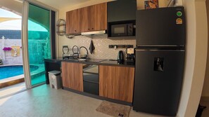 Eine moderne Küche mit eingebauter Mikrowelle, Kühlschrank und einer kleinen Spüle.