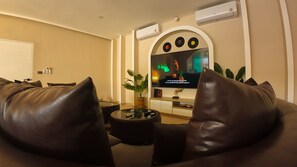 A modern living room with a leather sofa, a glass coffee table, and a flat-screen TV mounted on the wall. - Beautiful Private Pool Villa – Perfect Pattaya Escape (Pattaya City)