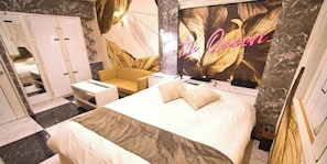 Una habitación de hotel con cama, sofá, escritorio y armario.