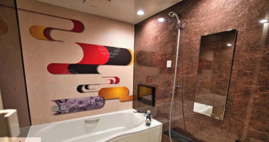 A modern bathroom with a large mirror, a bathtub, and a shower.