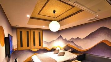 A room with a bed, a wall-mounted TV, and a ceiling light fixture.