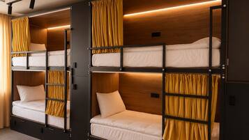 A bunk bed room with wooden walls, curtains, and a ceiling light fixture.