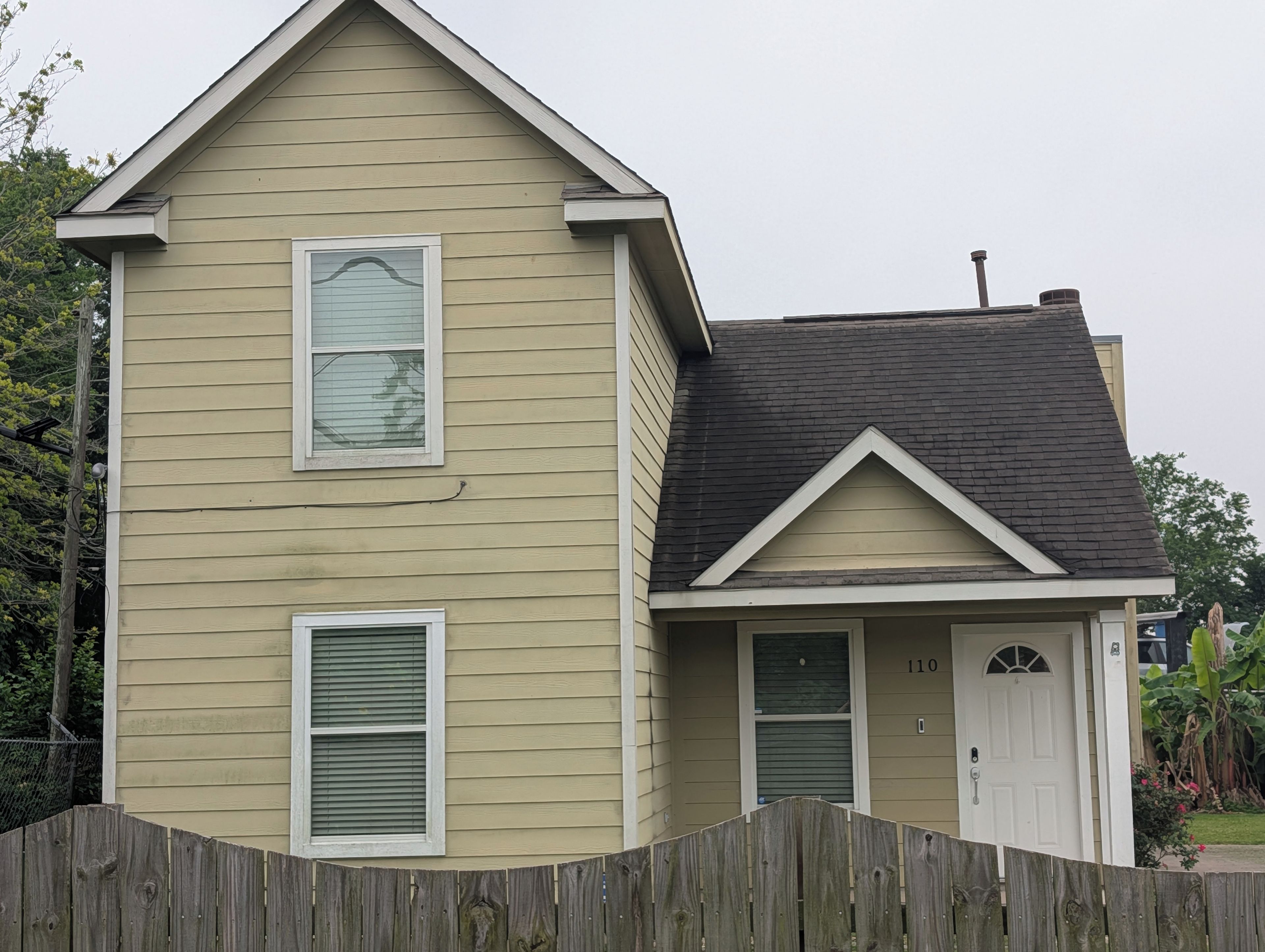 A two-story house with a gabled roof, a front door, and a mailbox.