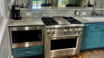 Una cocina moderna con horno empotrado, estufa y un amplio ventanal.