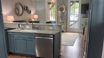 A modern kitchen with a central island, built-in appliances, and a view to the dining area.