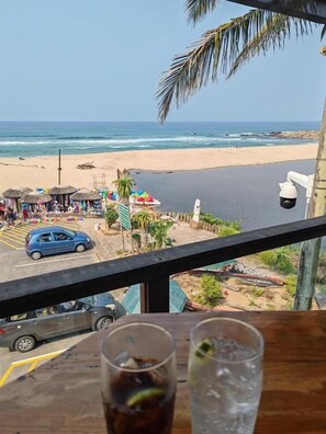 A beach view from a balcony with a table in the foreground. - Alomsee 20 Ramsgate 4 Bedroom Apartment (Margate)
