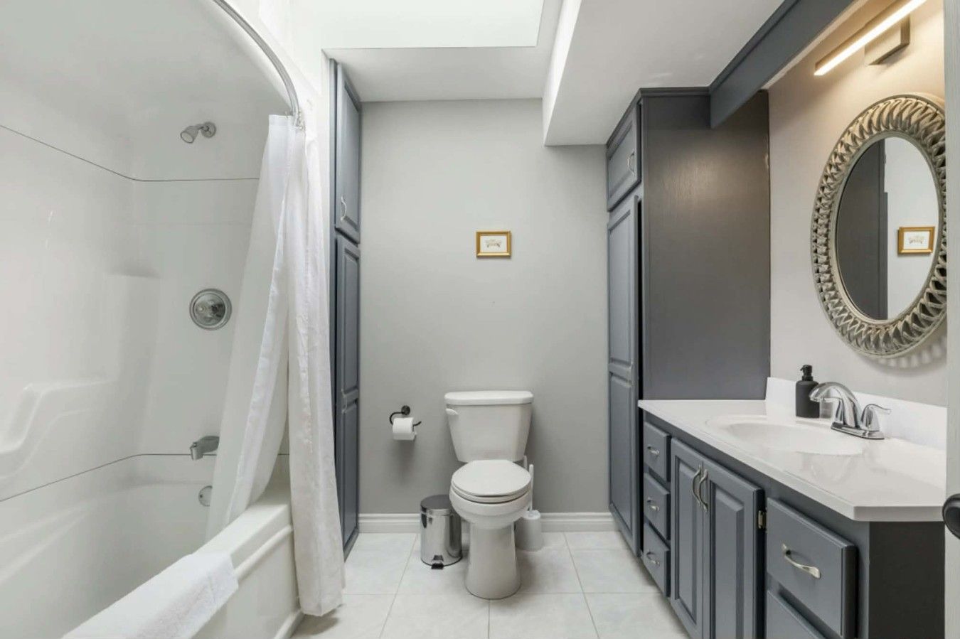 A modern bathroom with a bathtub, toilet, and vanity.