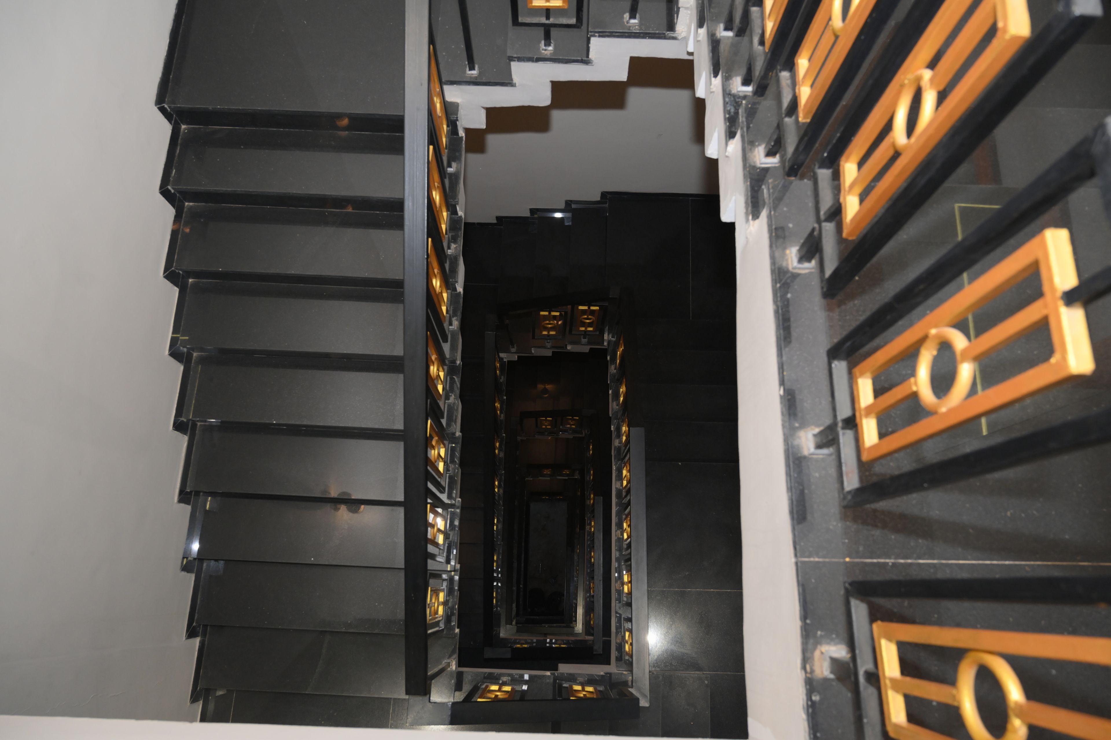 Un pasillo con una serie de puertas negras y doradas.