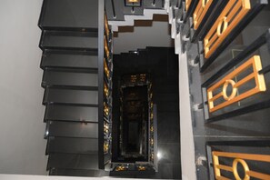 Un pasillo con una serie de puertas negras y doradas.