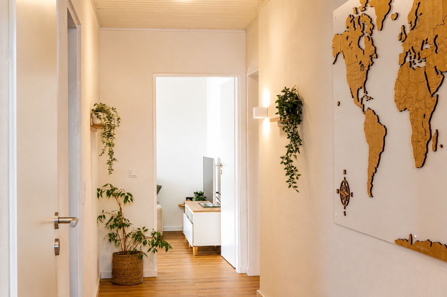 Ein Flur mit Holzboden, weißen Wänden und einer Weltkarte an der Wand.