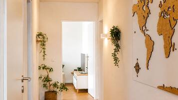 Ein Flur mit Holzboden, weißen Wänden und einer Weltkarte an der Wand.