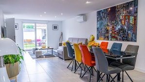 Un comedor moderno con una mesa dispuesta para cuatro personas, rodeada de sillas coloridas.