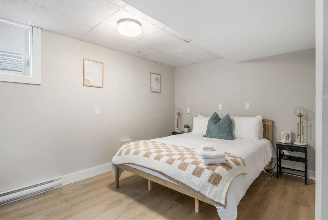 Een slaapkamer met een bed, nachtkastjes en een raam.
