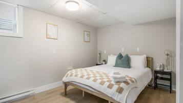 Een slaapkamer met een bed, nachtkastjes en een raam.
