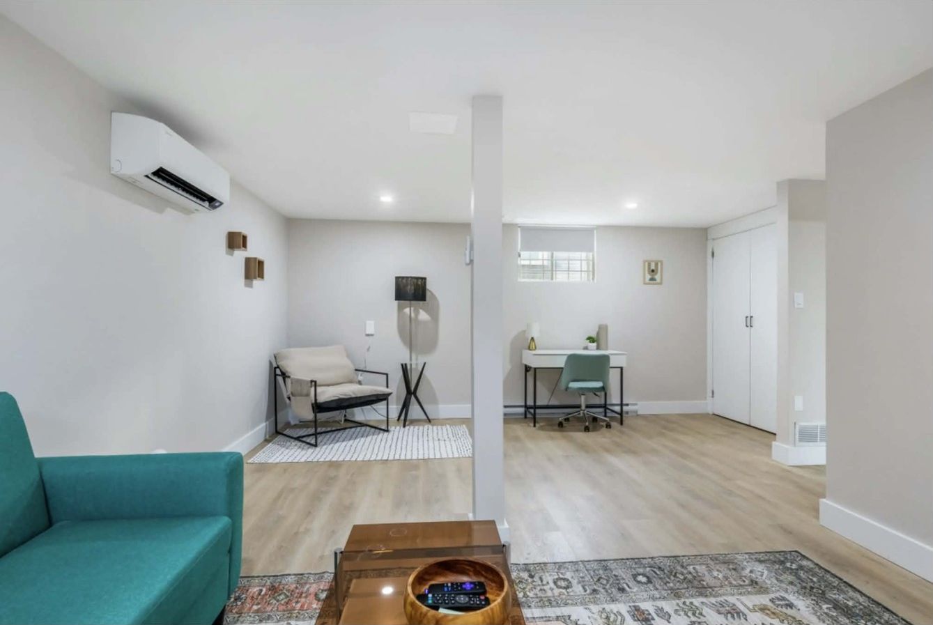 Un salon moderne comprenant un canapé, une table basse et un coin repas avec une table et des chaises.
