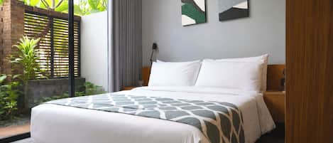 A modern bedroom with a large bed, a nightstand, a lamp, and two abstract paintings on the wall.