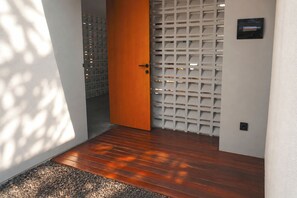 A wooden floor leading to a door with a white lattice panel. - Villa Daksa Ubud by Tasvan (Gianyar)