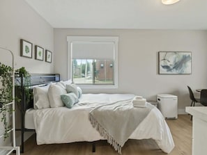 Una camera da letto moderna con un letto, un comodino e una finestra vista.