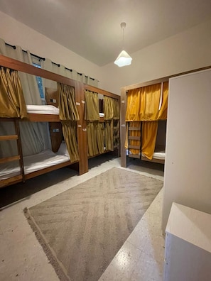 A room with bunk beds, a carpet, and a ceiling light.
