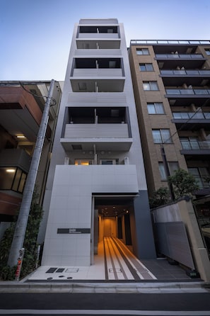 A multi-story building with a modern architectural design, featuring a prominent entrance with a ramp leading to the ground floor. - Dash Living Ueno Park (Bunkyo-ku, Yushima)
