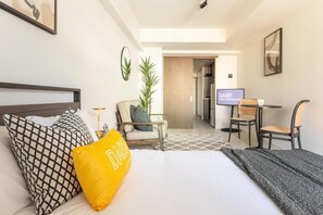 Ein Hotelzimmer mit einem Bett, einem Schreibtisch und einem Fernseher.
