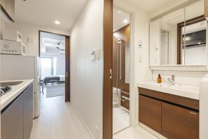 Ein modernes Badezimmer mit großem Spiegel, Dusche und Waschbecken.